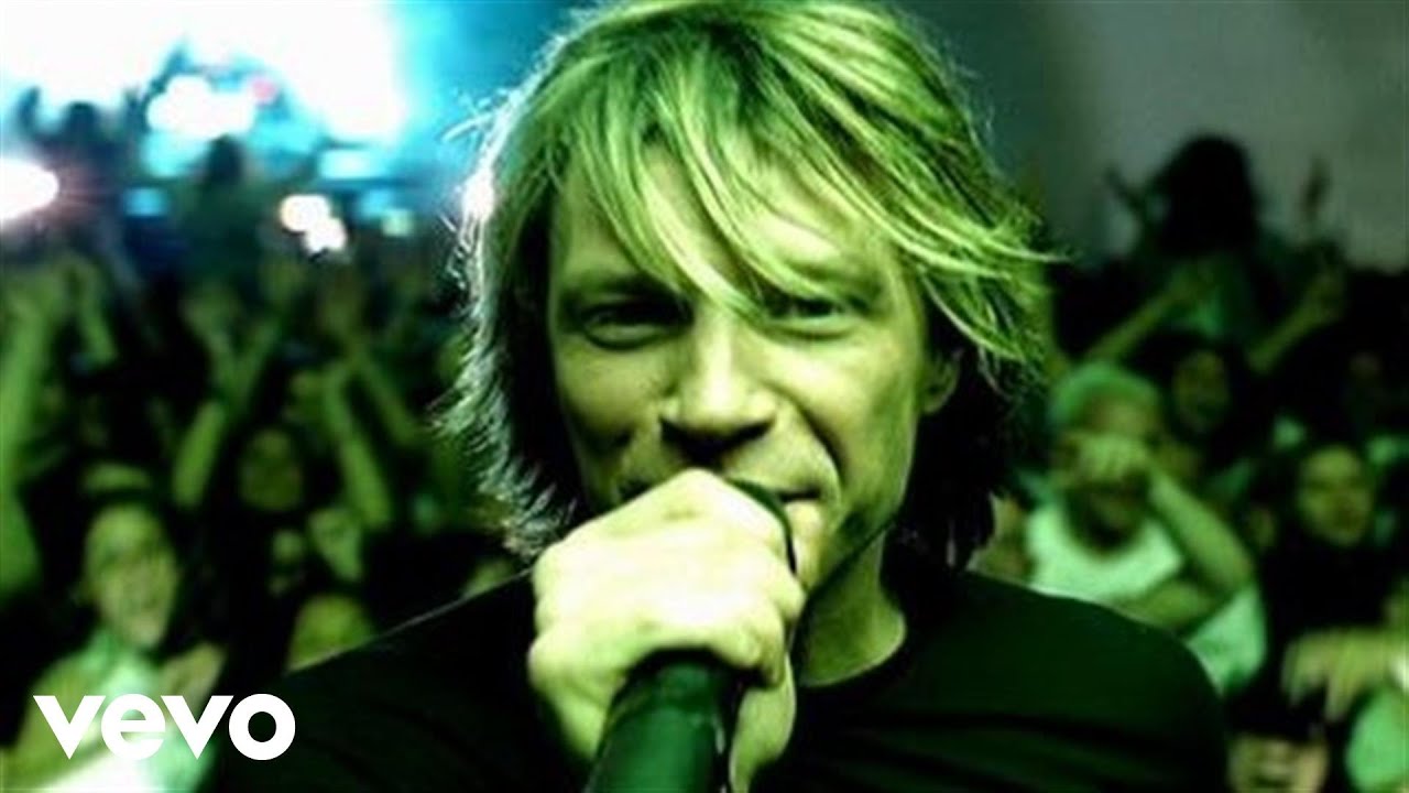 Bon Jovi - It's my life. Bon jovi is with a microphone looking straight at us, his audience crowd is filling the background