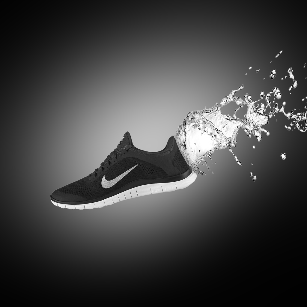 Shoe Dog Book Review Nike Black and white shoe on dimm background with splashing water coming out of it's back