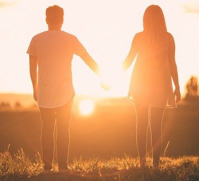 Man and woman holding hands at the sunset
